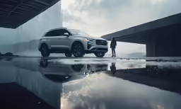 a man standing beside a car and a bridge