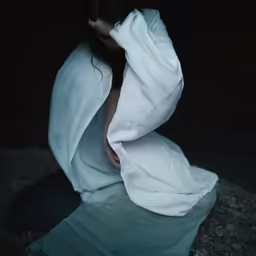 a person with their head in an empty blanket