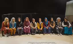 a group of people with colorful coats sitting together