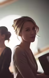 two women in black dresses in front of a wall