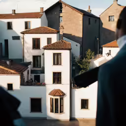 a man in a blue suit looking at the view from his house