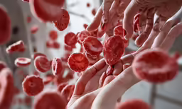 a group of blood cells being held together by three hands