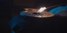 a candle on a black background that has one burning
