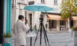 a photographer taking photos of the outdoor dining area in front of a building