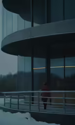 a person stands near some large glass building