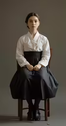 a woman in a dress and a woman sitting on a chair
