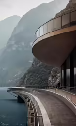an exterior view of a building and the sea with mountains in the background