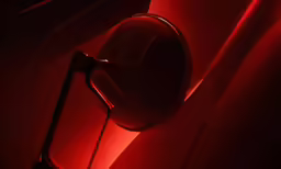 a bathroom mirror sitting on the wall next to a red light
