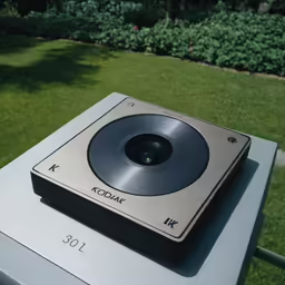 a metal record player is laying on a table outside