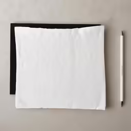 an inked pencil sits beside a piece of paper