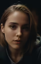 a woman in a black coat looking at the camera