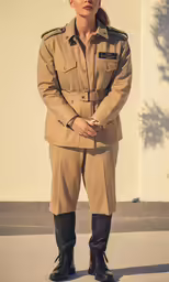 a woman in uniform is standing by the wall