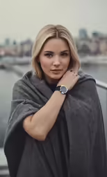 a blonde woman with a cape wrapped around her shoulders