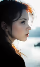 a woman looking off into the distance near the water