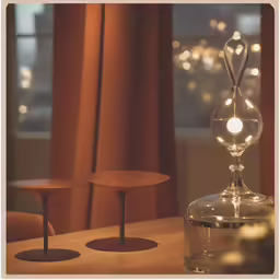 an empty glass is next to some small table in a darkened room