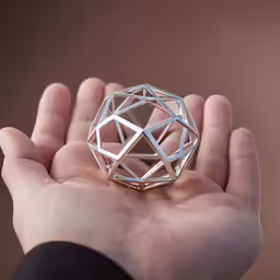 the image shows someones hand holding a small decorative object