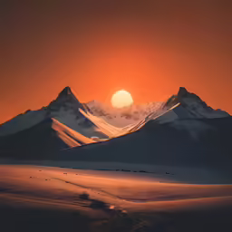 the sun rising over mountains with snow on them