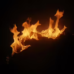 a close up shot of some flames against a black background