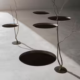 four tree branches growing from a circular metal pot