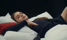 a woman is laying on the white sheets