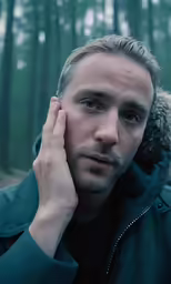 a man in a jacket looking off into the distance
