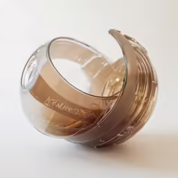 a silver tea cup with a clear top sitting on the floor