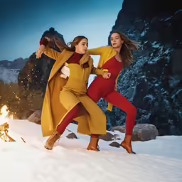 two girls wearing yellow and orange are dancing