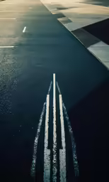 an airplane flies past a strip of asphalt