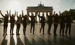 a group of people standing on a street next to the berlin wall