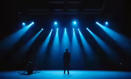the person is looking at the stage lights