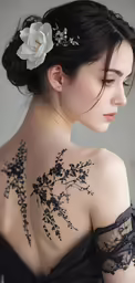 the back of a woman with flowers and vines on her shoulder