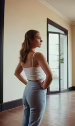 a woman in jeans and a tank top, looking away