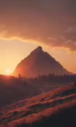 the sun is setting behind the mountain peak