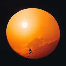 the sun setting as seen from a telescope at sunset