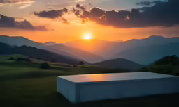 the sun sets over the mountains with some clouds in the sky