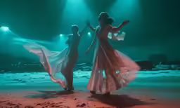 two women in long, flowing dress on a stage