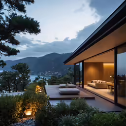 a house with a deck and outdoor lighting near the water