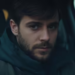 a man with a beard wearing a black jacket