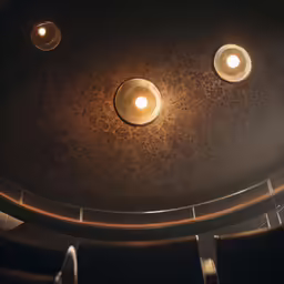 three light fixtures are glowing brightly on a table
