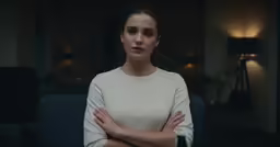 a young woman standing with her arms crossed