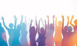 group of people with arms raised up against a colored background