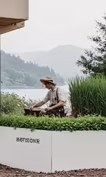 a man is working in the garden on the side of the building