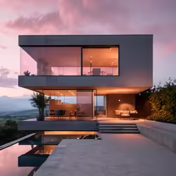 a modern house with water and a sunset