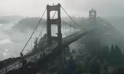the suspension bridge is almost overcast and there is mist on the water