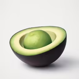 an avocado cut in half and placed on the white table