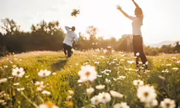 two people playing in the grass with a flying disc