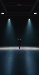 a person sitting alone in the dark with bright lights