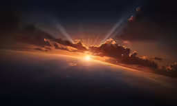 a sun going down over the ocean with clouds and water