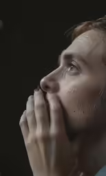 a man with his hand to his mouth