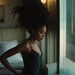 a woman that is standing up next to a window